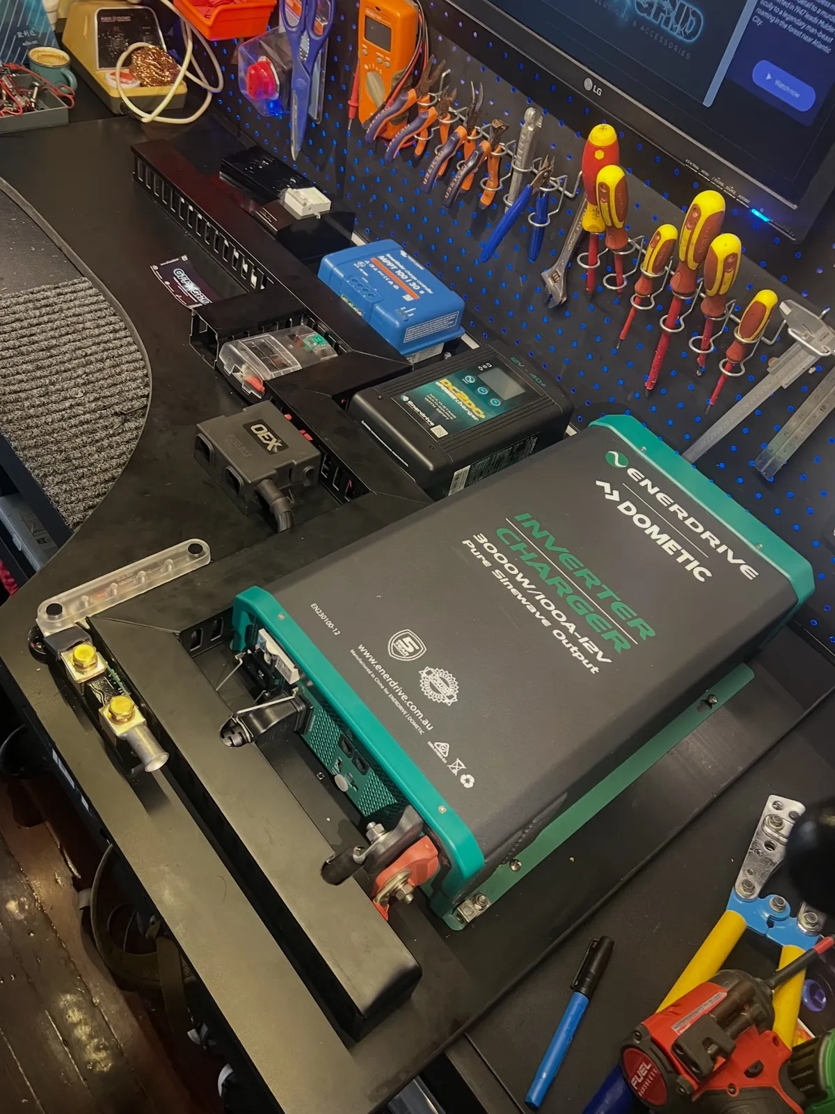 Enerdrive inverter charger and DC-DC charger mounted on a custom board on the workshop bench