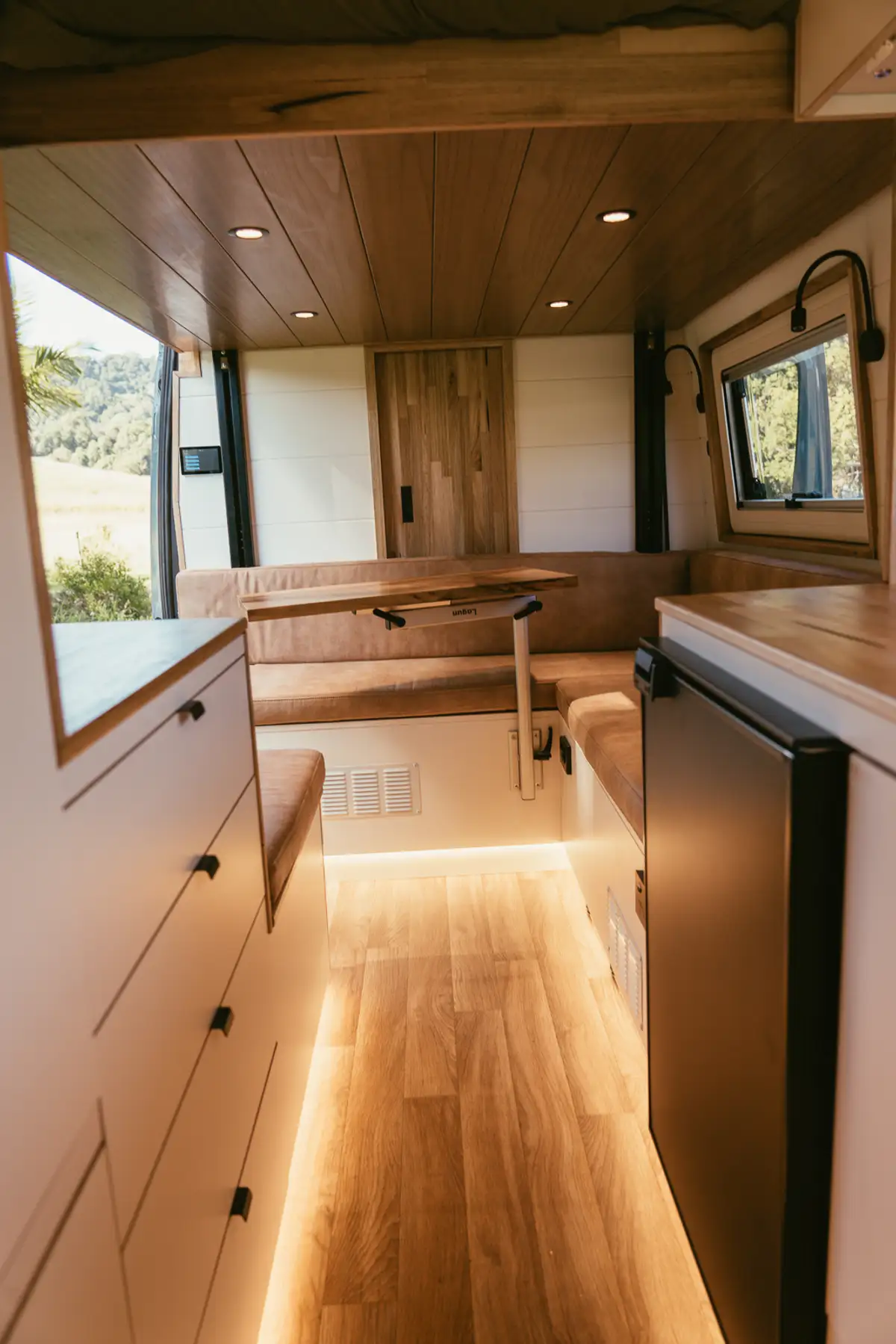 Van interior with dimmable warm downlights and a floor-level LED strip